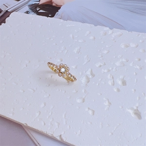 Macro detail of 18K gold plated ring featuring flower shape with pearls and zircons