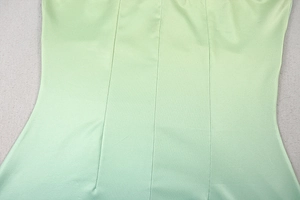 Detail view of the light green gradient dress waistline with vertical stitching