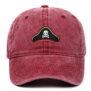 Vintage washed red cotton baseball cap featuring embroidered pirate skull on front