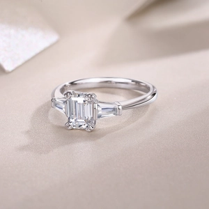 Macro view of emerald-cut moissanite ring with tapered baguette side stones