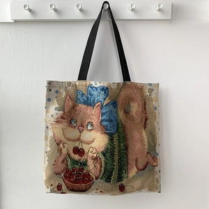 Detail of jacquard tote bag featuring cartoon cat and cherry patterns on woven fabric