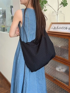 Sac à bandoulière hobo noir avec texture gaufrée creuse au style vintage épuré