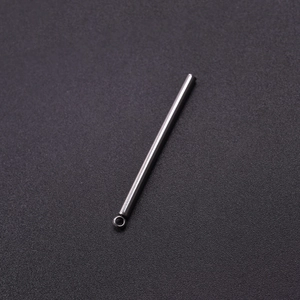 Macro shot of silver stainless steel cylindrical tube pendant on black textured background