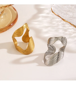 Macro detail of gold and silver irregular wavy rings with brushed metal texture