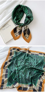 Detail of silk scarf with green tiger print, leopard patterns and gold chains