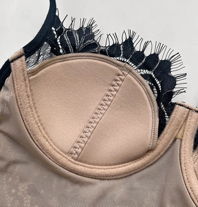 Close-up of beige mesh bra interior with black eyelash lace trim and quality stitching