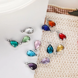 Macro view of teardrop birthstone charms with faceted glass and silver metal frames