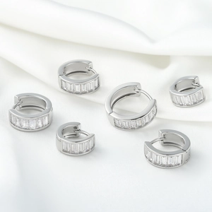 Three pairs of silver huggie hoop earrings with baguette cut cubic zirconia in various sizes