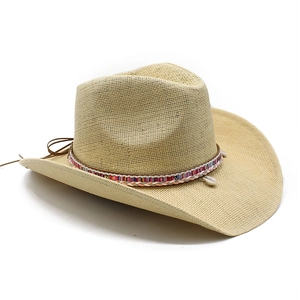 Detail eines Stroh-Cowboyhuts mit buntem Webband und Muschel-Anhängern für den Sommer