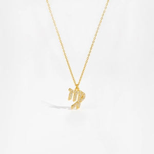 Macro shot of gold S925 sterling silver Virgo zodiac pendant with white zircons