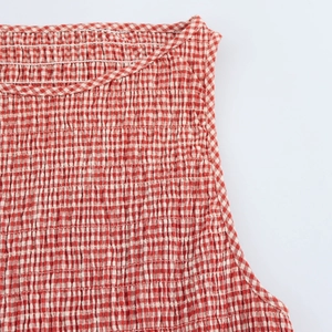 Macro view of red and white plaid fabric with smocked elastic texture on the dress