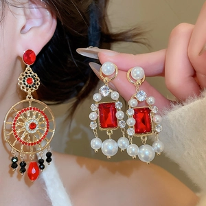 Gros plan de boucles d'oreilles vintage avec pierres rouges et perles sur un mannequin