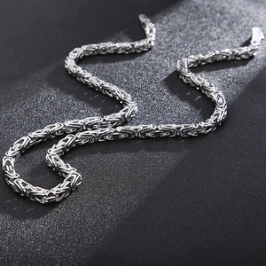 Close-up of silver Byzantine chain necklace featuring thick link texture and lobster clasp