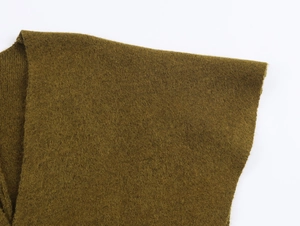 Gros plan du tissu en maille vert olive montrant la texture douce et les coutures