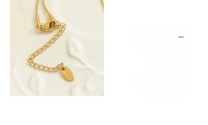 Close-up of golden extension chain with K18 engraved tag and lobster clasp detail