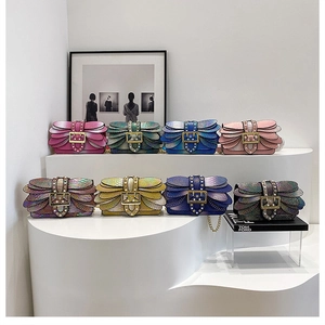 Detail of multi-colored snake skin crossbody bags with pearl buckles and metal chain straps