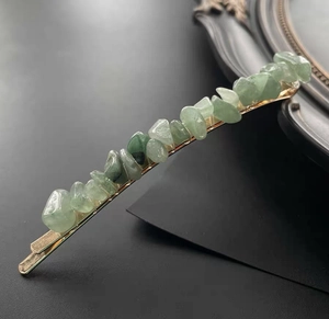 Detailed view of natural green crystal stones set on a golden alloy hair pin