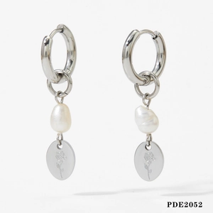 Detailed view of silver hoop earrings with baroque pearl and rose engraved pendant