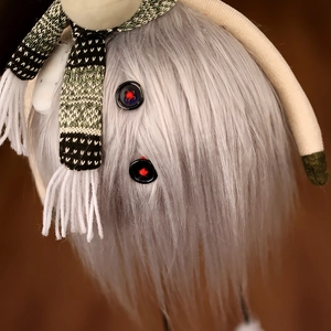 Detail of plush reindeer texture with green striped scarf and button decorations