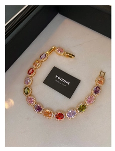 Detail of colorful oval gemstones with diamond halo and gold plated bracelet clasp