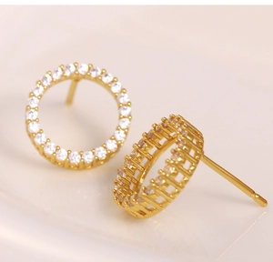 Close-up of gold-plated circular stud earrings with micro-paved cubic zirconia stones