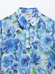 Detail of floral print blouse with button-up front and branded size label on neckline