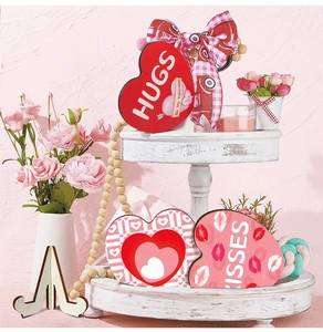 Three Valentine heart-shaped wooden plaques with Hugs and Kisses on white tray