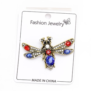 Detail of vintage gold bee brooch with rhinestones and colorful gemstones on card