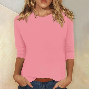 Detalle de camiseta rosa entallada con cuello redondo y manga de tres cuartos en modelo