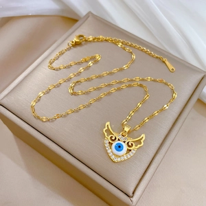 Luxurious gold stainless steel evil eye wing heart necklace on white silk background