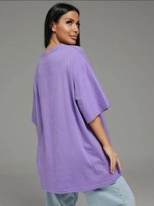 Λεπτομέρεια από μωβ βαμβακερό oversized t-shirt που δείχνει τη γραμμή και την υφή