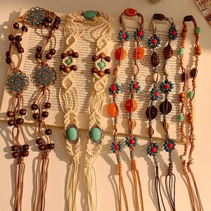 Chaîne de taille boho avec perles de bois et coquillages sur fond de livre ancien