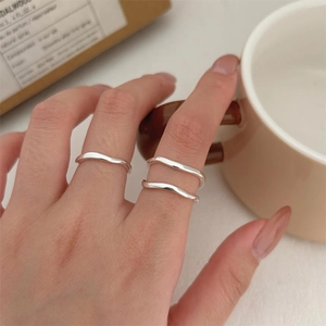 Minimalist 925 sterling silver wavy open rings set worn by model in a soft lifestyle setting
