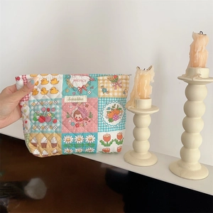 Close-up of quilted floral cosmetic bag with colorful patchwork and cute cartoon prints