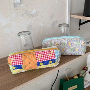 Dettaglio di astucci trapuntati a fiori e borse per il trucco con design patchwork colorato