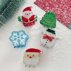Close-up of five-piece glitter Christmas hair clips set with Santa and snowman motifs