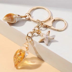 Detailed view of creative beach shell and starfish pendants on a golden keychain