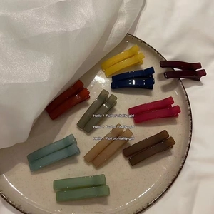 Colorful jelly rectangle hair clips set for women on a ceramic plate minimalist style