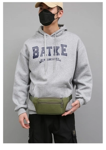 Detail of army green canvas waist bag with adjustable nylon strap and multi-pocket design
