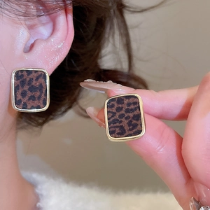 Gros plan de boucles d'oreilles carrées léopard avec détails de bordure en métal doré