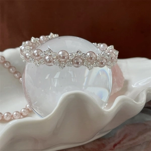 Detail of pink pearl and crystal beaded bracelet on a decorative shell porcelain plate