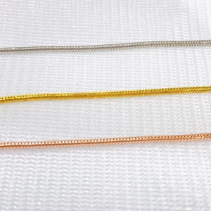 Close-up of 18k gold snake bone chain necklaces in silver, gold and rose gold finishes