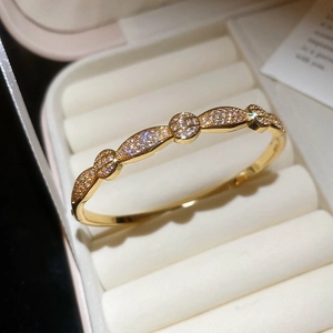 Macro detail of gold plated zircon bangle with intricate pave setting in a gift box