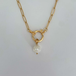 Close-up of golden link chain necklace featuring a white pearl pendant and round clasp