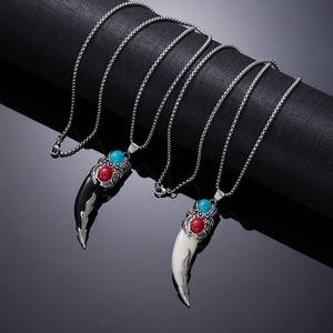 Macro detail of vintage wolf tooth necklaces with gemstones on metal pendants