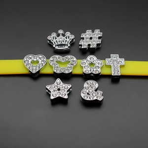 Close-up of assorted 10mm chrome alloy slide charms with rhinestones for DIY wristbands