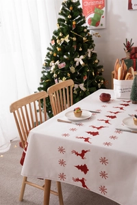 Detailed view of waterproof Christmas tablecloth with red reindeer and snowflake prints