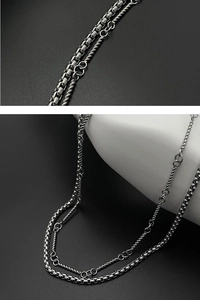 Detailed view of silver double-layered necklace featuring bead and rope chain styles