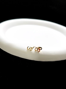 Detailed view of gold-tone 3D flower stud earrings featuring an elegant hollow petal design