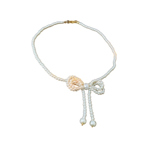 Elegant pearl choker necklace featuring a delicate crystal bow pendant and gold clasp design